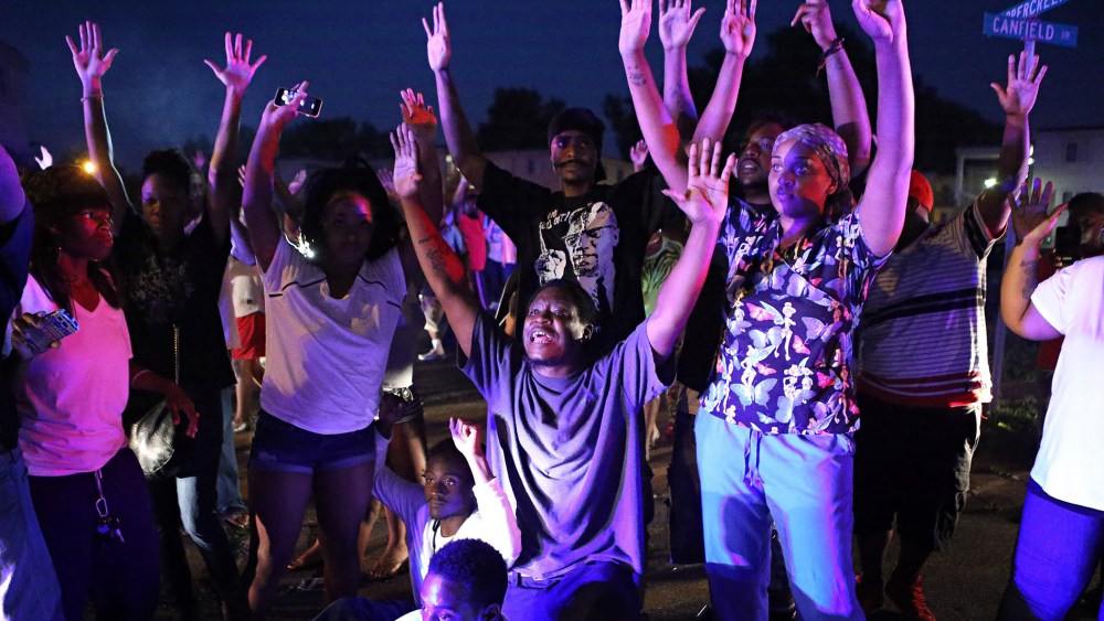 "Don't shoot us'' cries out the crowd as they confront police officers arriving to break up a crowd in Ferguson, Mo., Aug. 9, 2014.