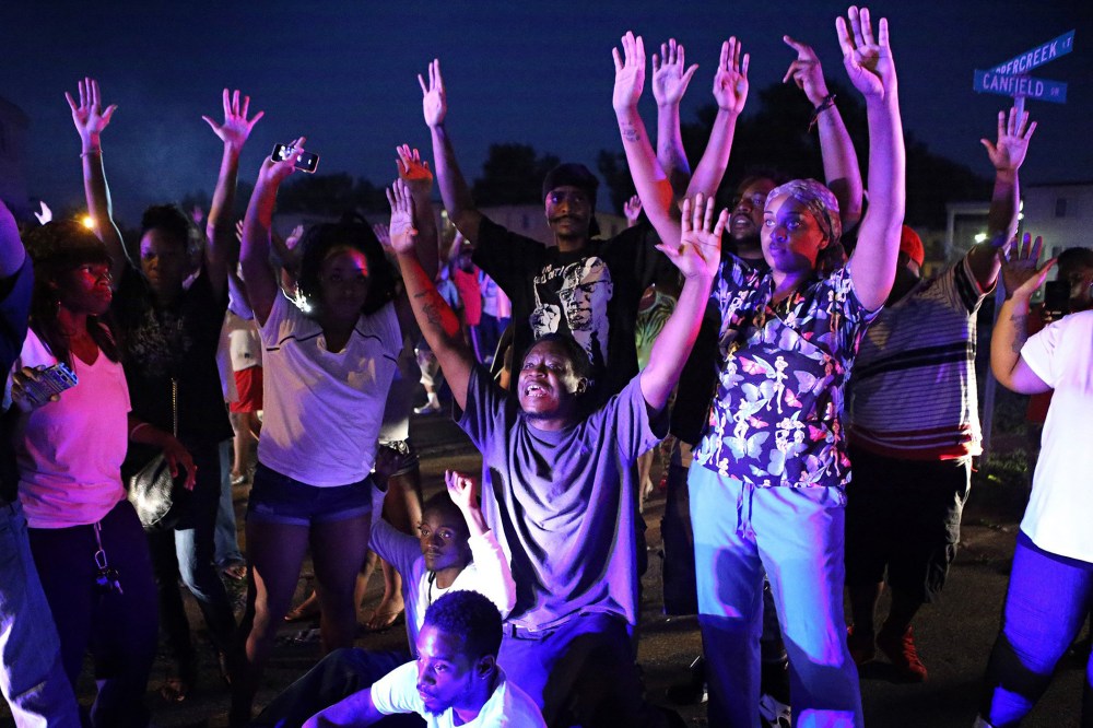 "Don't shoot us'' cries out the crowd as they confront police officers arriving to break up a crowd in Ferguson, Mo., Aug. 9, 2014.