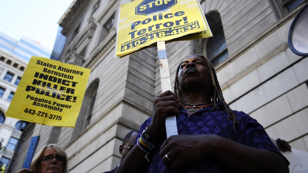 Protestors hold signs outside of the Clarence Mitchell Jr. Courthouse in Baltimore, Maryland, Aug. 14, 2014.