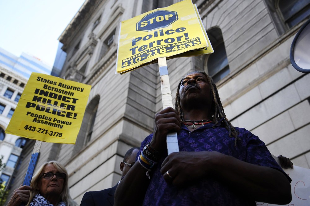 Protestors hold signs outside of the Clarence Mitchell Jr. Courthouse in Baltimore, Maryland, Aug. 14, 2014.