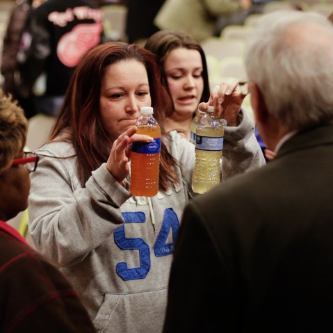 LeeAnne Walters shows water samples from her home from Jan. 21, 2015 to Flint's new emergency manager Jerry Ambrose at City Hall, Flint, Mich. (Photo by William Archie/Detroit Free Press/ZUMA)
