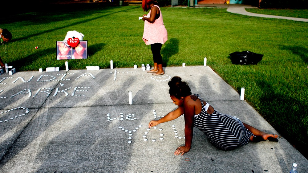 Lashell Bell, 18, right, of Tampa places candles spelling out ''We Love You'' during a vigil on July 22, 2015 in Florida, in memory of India Clarke. (Photo by Octavio Jones/Tampa Bay Times/Zuma)