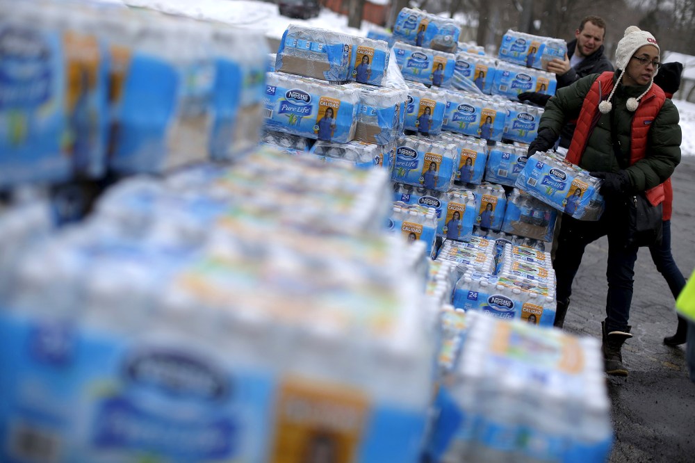 Volunteers distribute bottled water to help combat the effects of the crisis when the city's drinking water became contaminated with dangerously high levels of lead in Flint, Mich., March 5, 2016. (Photo by Jim Young/Reuters)