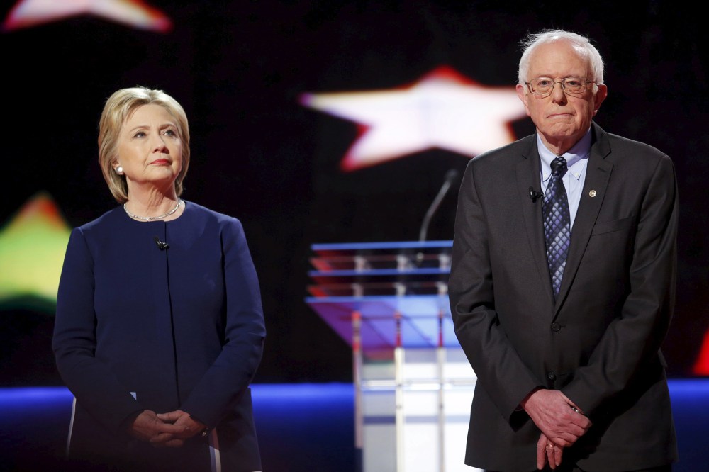 Democratic presidential candidates Hillary Clinton and Bernie Sanders pose together onstage at the start of the U.S. Democratic presidential candidates' debate in Flint, Mich., March 6, 2016. (Photo by Carlos Barria/Reuters)