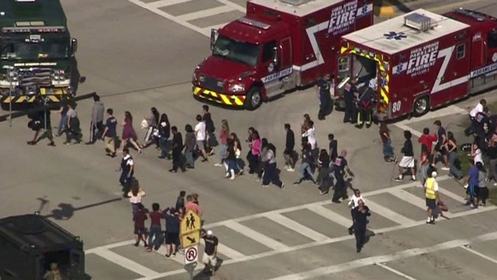 Image: Students are evacuated from Marjory Stoneman Douglas High School during a shooting incident in Parkland