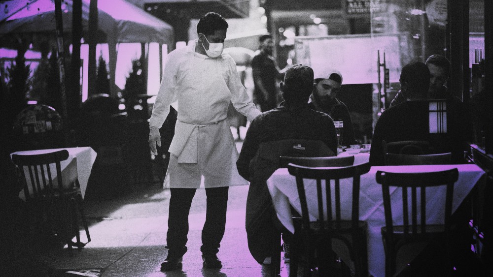 IMage: A restaurant employee moves between tables in Manhattan on Dec. 11, 2020.