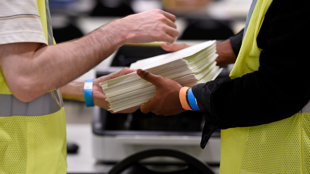 Cobb County Election officials handle ballots during a machine recount on Nov. 24, 2020, in Marietta, Ga.