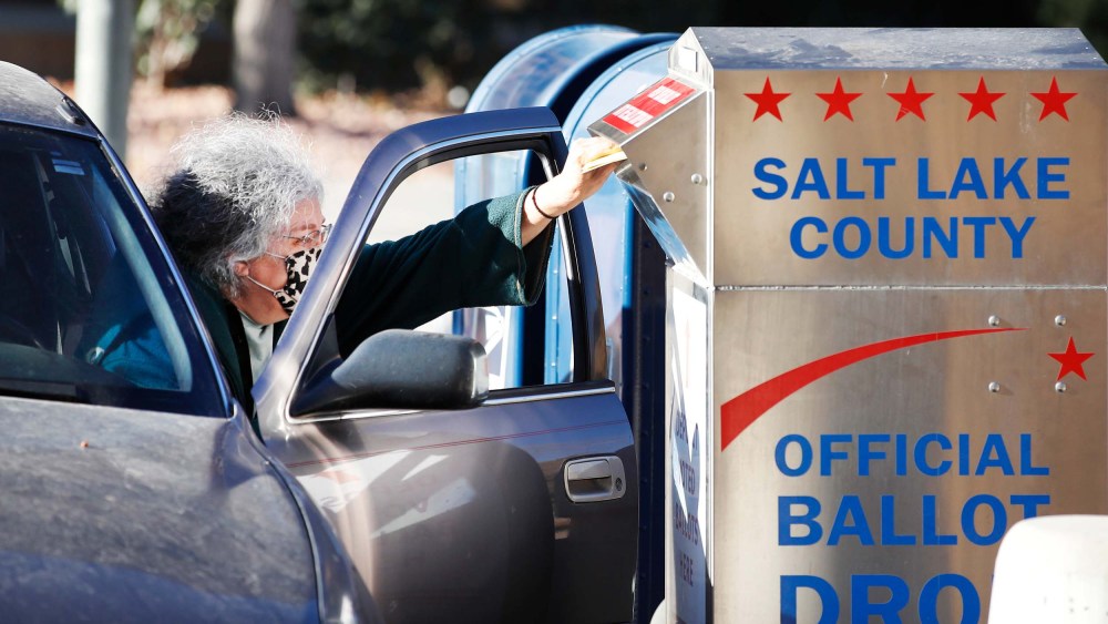 A voter drops off her mail in ballot at a dropbox at the Salt Lake County election office in Utah on October 29, 2020.