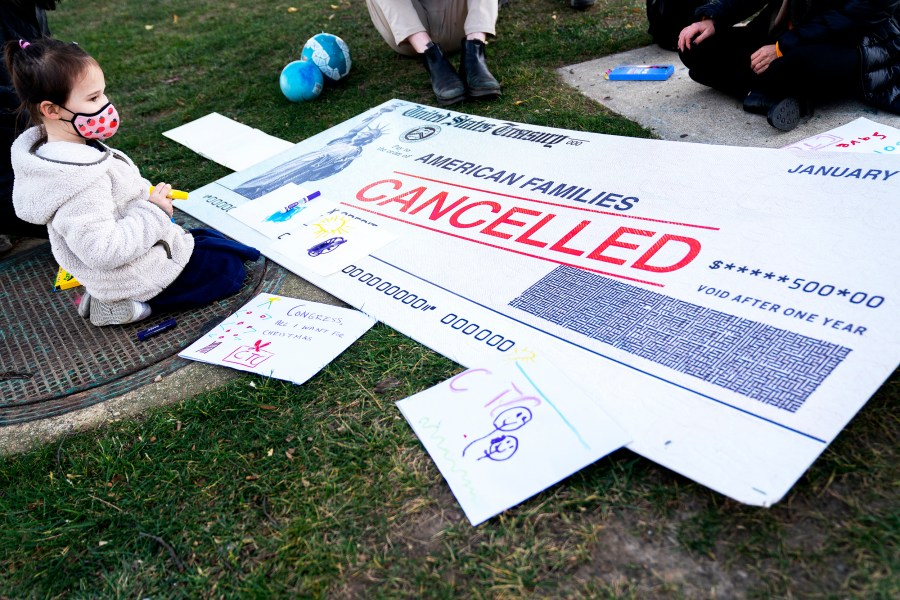 A child sits among activists calling for the extension of the Child Tax Credit outside the Capitol in Washington D.C. on December 13, 2021.