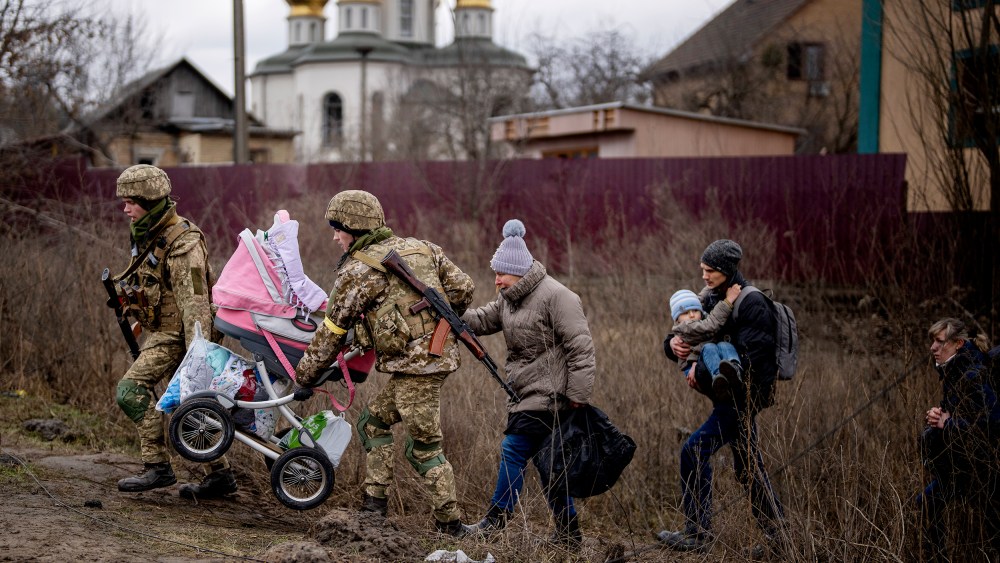 Ukrainian soldiers help a fleeing family crossing the Irpin river in the outskirts of Kyiv, Ukraine on Saturday, March 5.