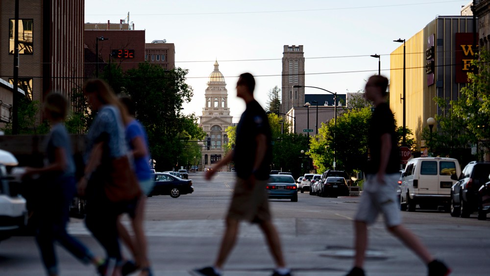 Pedestrians cross the street near the Wyoming State Capitol in downtown Cheyenne, Wyoming on June 19, 2019.