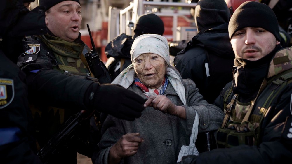 An elderly woman is helped by policemen after she was rescued by firefighters from inside her apartment after bombing in Kyiv, Ukraine on Tuesday, March 15.