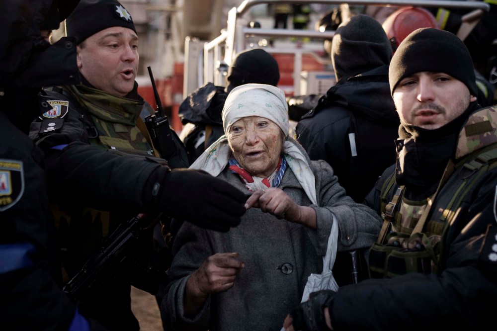 An elderly woman is helped by policemen after she was rescued by firefighters from inside her apartment after bombing in Kyiv, Ukraine on Tuesday, March 15.