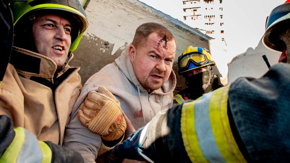 Rescuers evacuate a man from under the rubble of damage by shelling of the National Academy of State Administration building in Kharkiv, Ukraine, Friday, March 18.