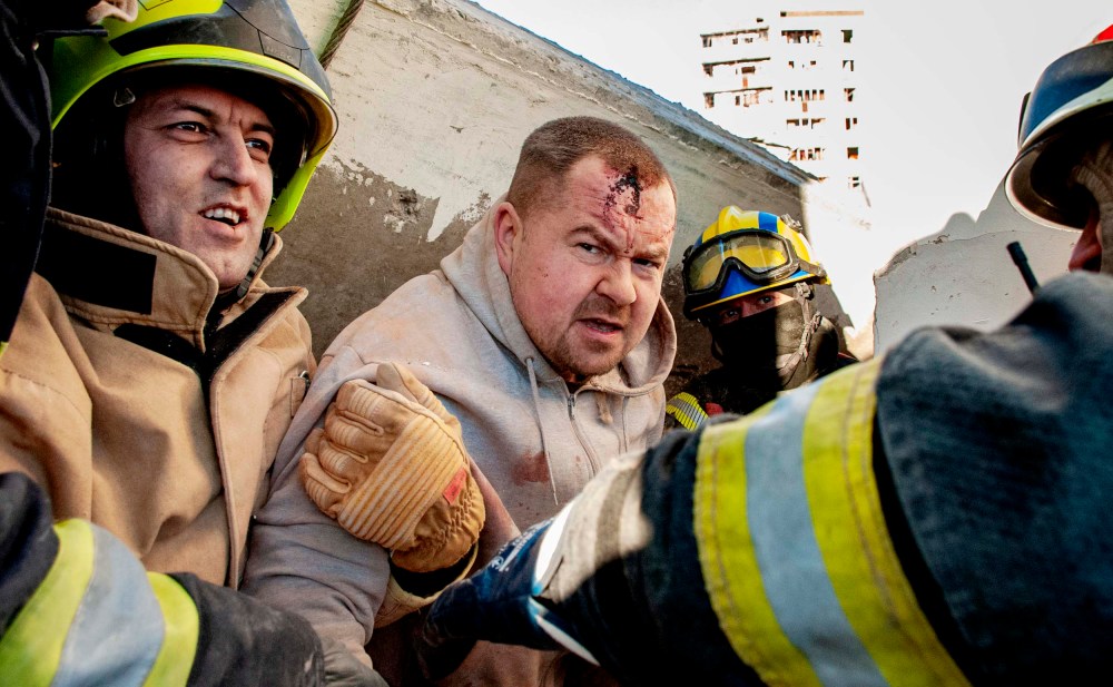 Rescuers evacuate a man from under the rubble of damage by shelling of the National Academy of State Administration building in Kharkiv, Ukraine, Friday, March 18.