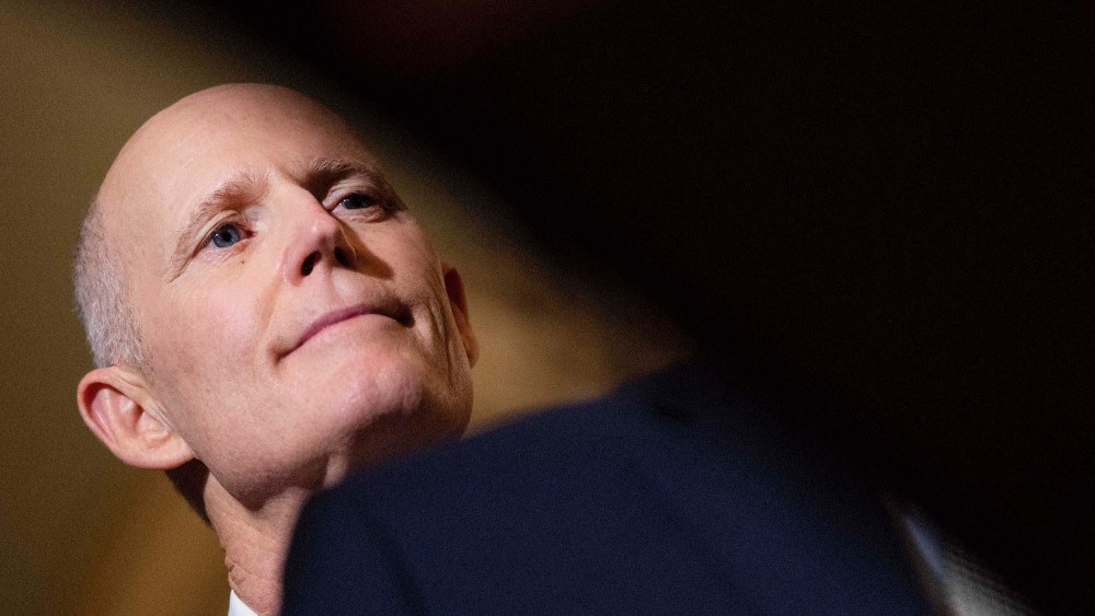 Sen. Rick Scott listens as Senate Minority Leader Mitch McConnell speaks to reporters at the U.S. Capitol March 22 in Washington, D.C.