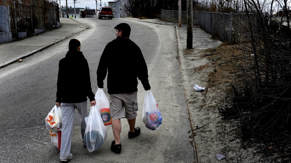WOONSOCKET, RI - MARCH 01: (L) Amanda Aubin and Cody Allison carry $70.00 worth of groceries to their apartment about one-half mile away. They had money left over on their food stamp card but this amount of food was all that they could carry on foot. Some of the items purchased were for their 4 year-old daughter who was having a birthday party the next day. Many families and individuals in Woonsocket, Rhode Island are needy and take part in the SNAP (food stamps) program.