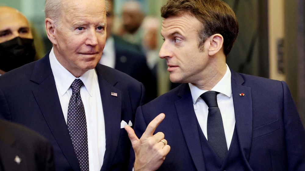 President Joe Biden speaks with France's President Emmanuel Macron ahead of an extraordinary NATO summit at NATO Headquarters in Brussels on March 24.