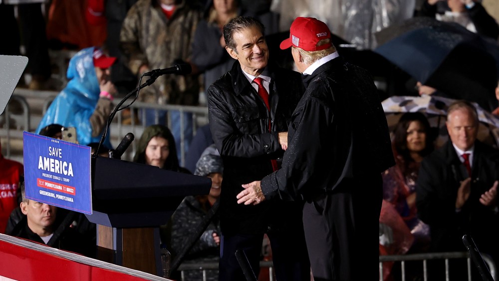 Image: Senate candidate Mehmet Oz and former President Donald Trump shake hands at a rally in Greensburg, Pa.,  on May 6, 2022.