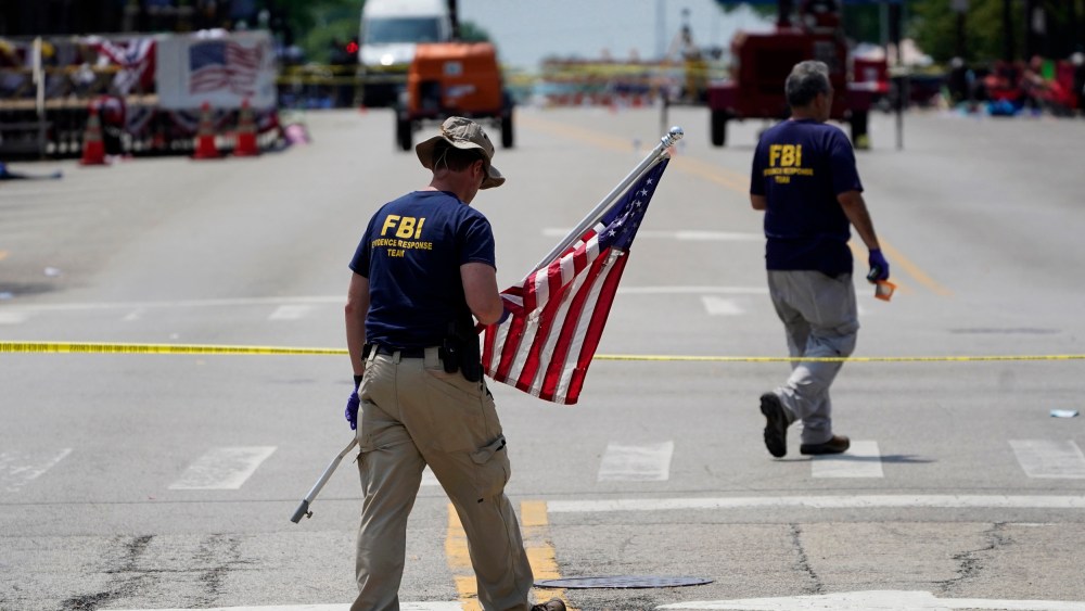 Image: Members of the FBI's evidence response team investigate the scene of a mass shooting in Highland Park, Ill., on July 5, 2022.