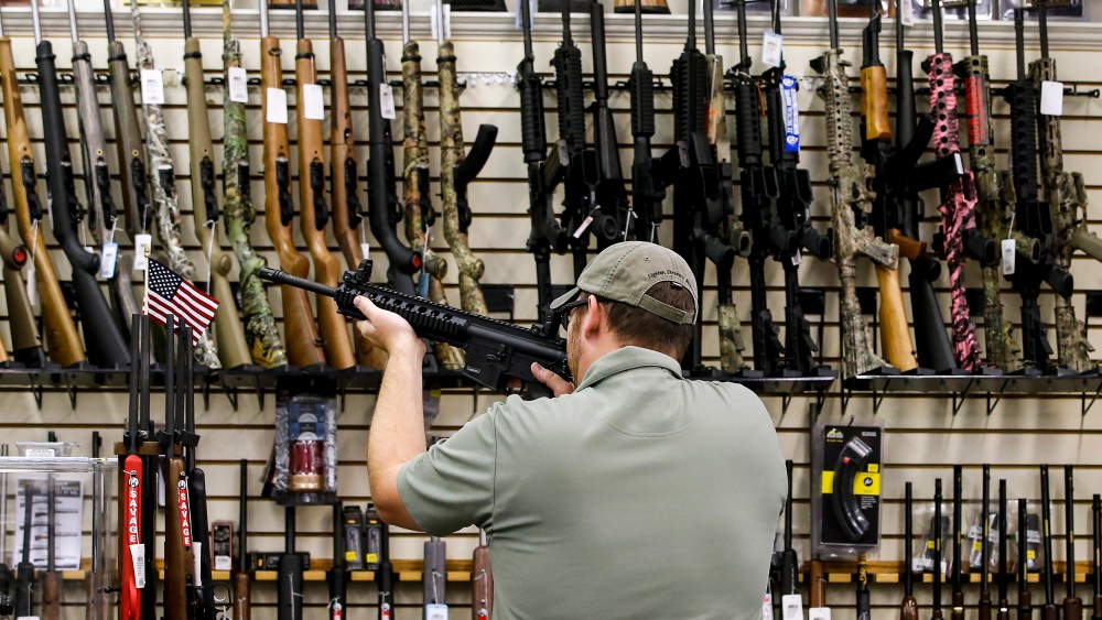 A customer holds an AR-15 riffle at a gun store in Orem, Utah, on Aug. 11, 2016.