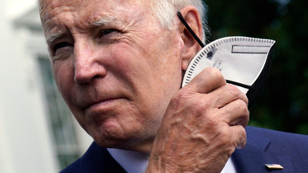 Image: President Joe Biden removes his mask.