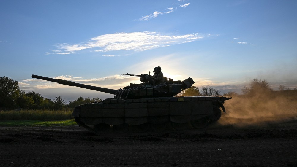 Image: Soldiers riding a tank.