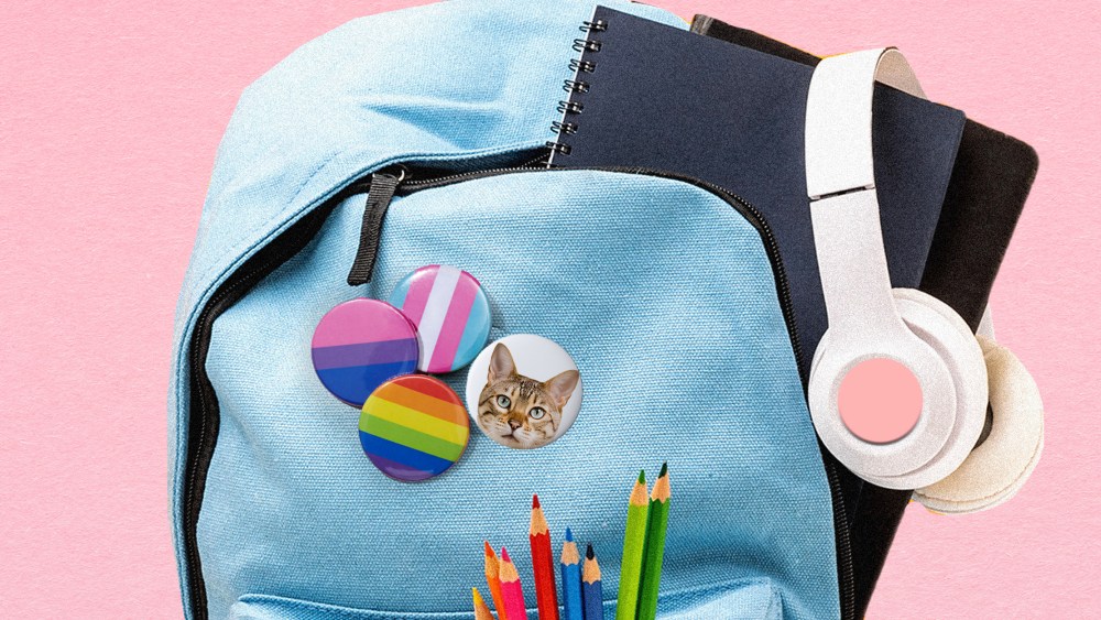 Photo illustration: Badges with the LGBTQ pride flags and a picture of a cat pinned to a school backpack.