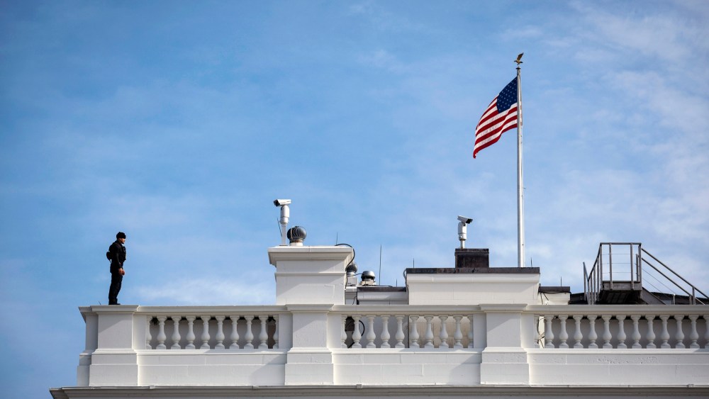Image: A Secret Service agent stands guard on the roof of the White House in Washington in 2020.