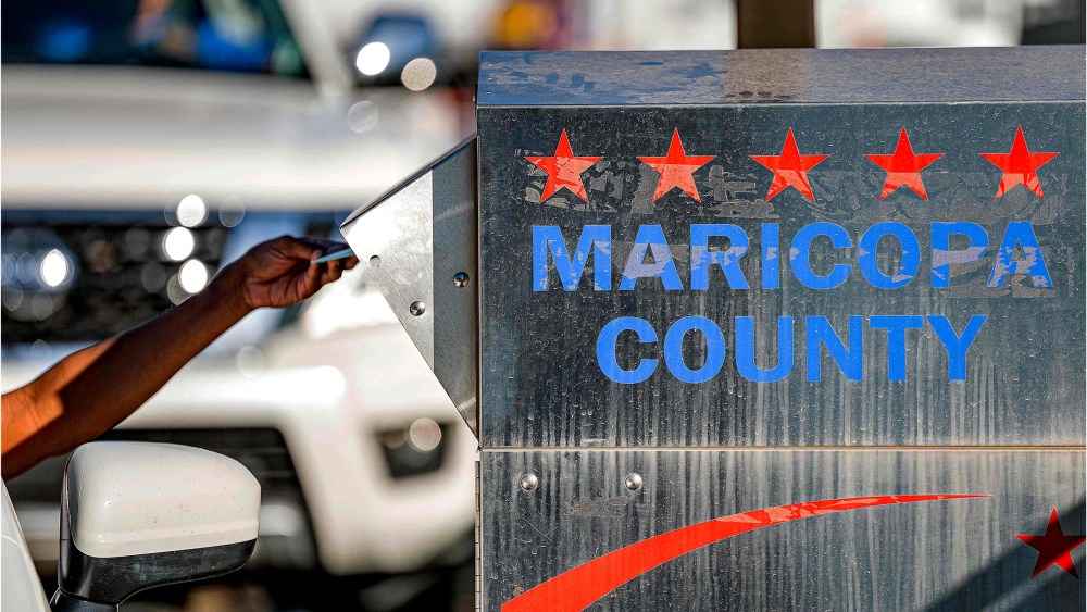 Image: A voter drops their ballot in a dropbox in the midterm election at the Maricopa County Tabulation and Election Center.