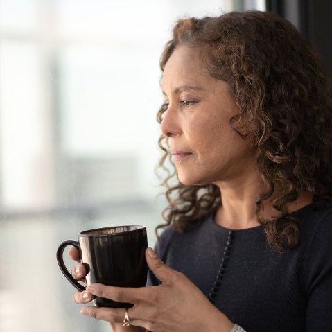 Portrait of a beautiful black woman drinking tea by window