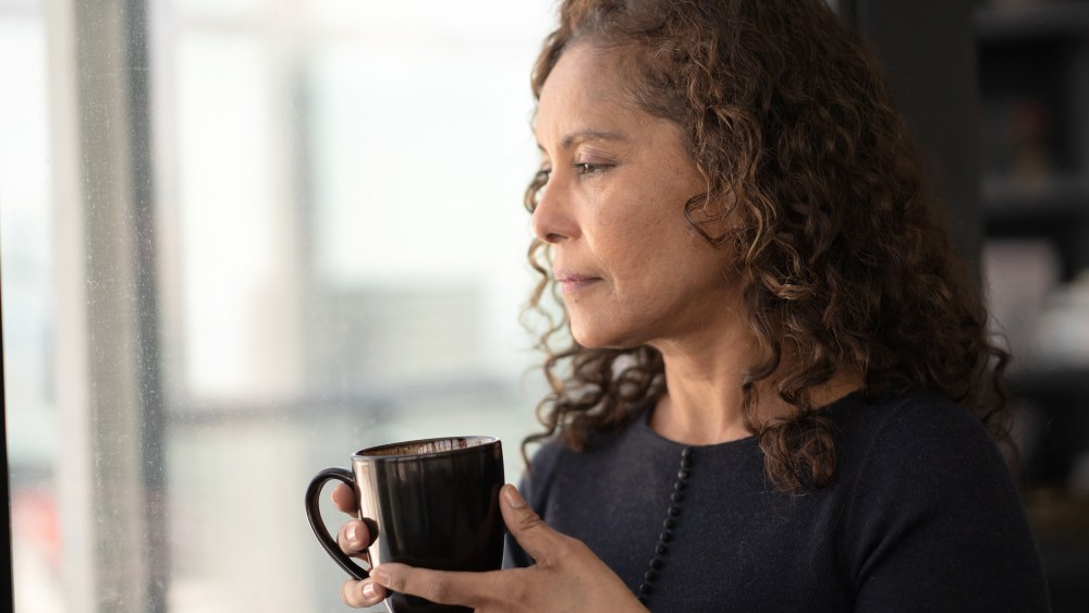 Portrait of a beautiful black woman drinking tea by window
