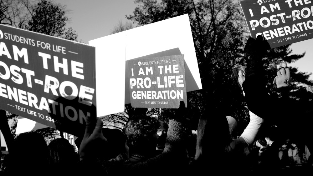 Image: Anti-abortion demonstrators outside the Supreme Court  walking with signs that read,"Students for Life, I am the Post-Roe Generation".