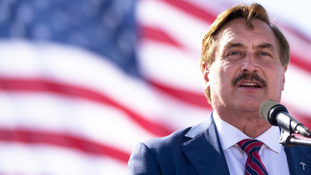 Image: Mike Lindell speaking with the American behind him.