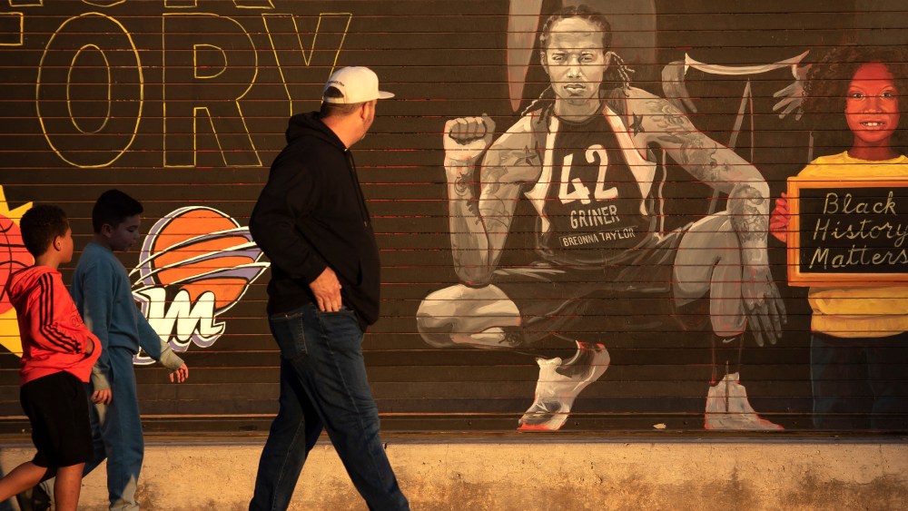 Image: People walk by a mural of Brittney Griner outside of the Footprint Center in Phoenix, Arizona.