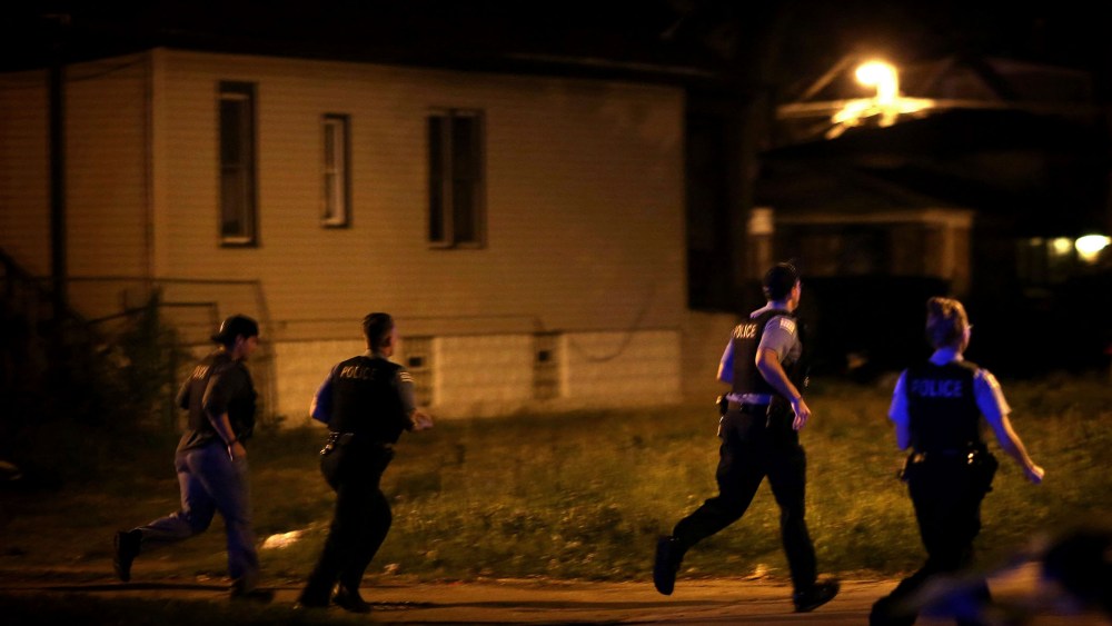 Chicago police respond to gunfire while searching for a gunman after finding three gunshot victims in the early hours of July 7, 2014, in Chicago.