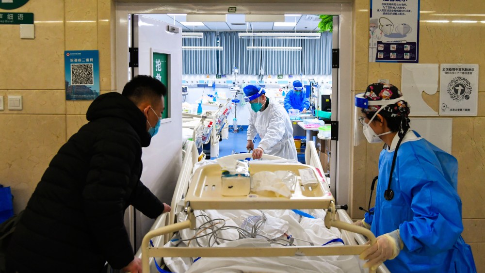 Image: Medical workers move a patient into emergency care unit at Peking University Third Hospital in Beijing.