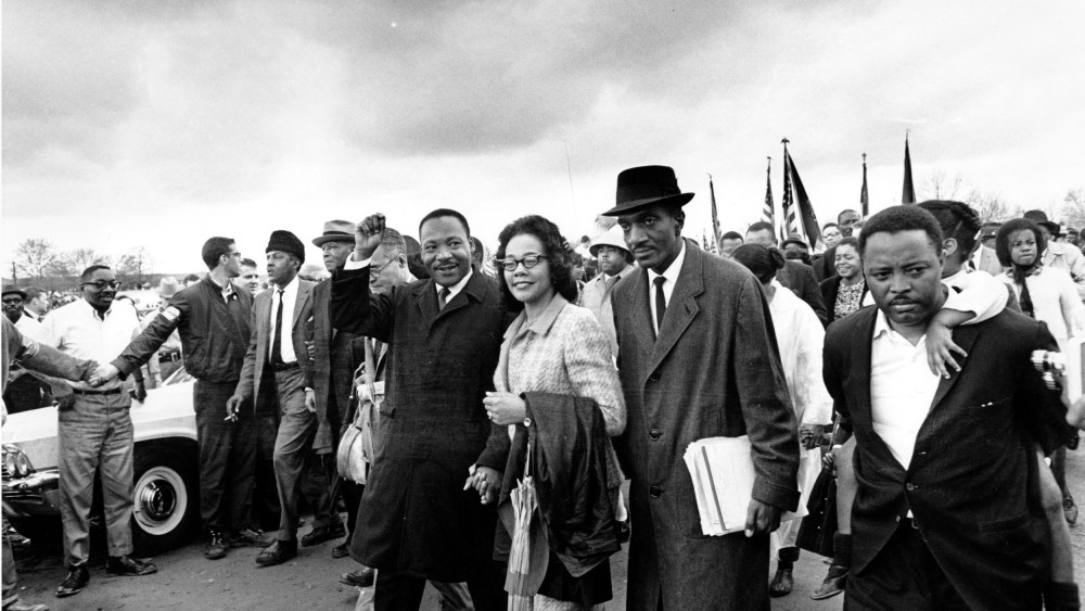 Dr. Martin Luther King Jr., and his wife, Coretta Scott King, lead off the final lap to the state capitol at Montgomery, Ala., on March 25, 1965.  Thousands of civil rights marchers joined in the walk, which began in Selma, Ala., on March 21, demanding voter registration rights for blacks. Rev. D.F. Reese, of Selma, is at right.  (AP Photo)