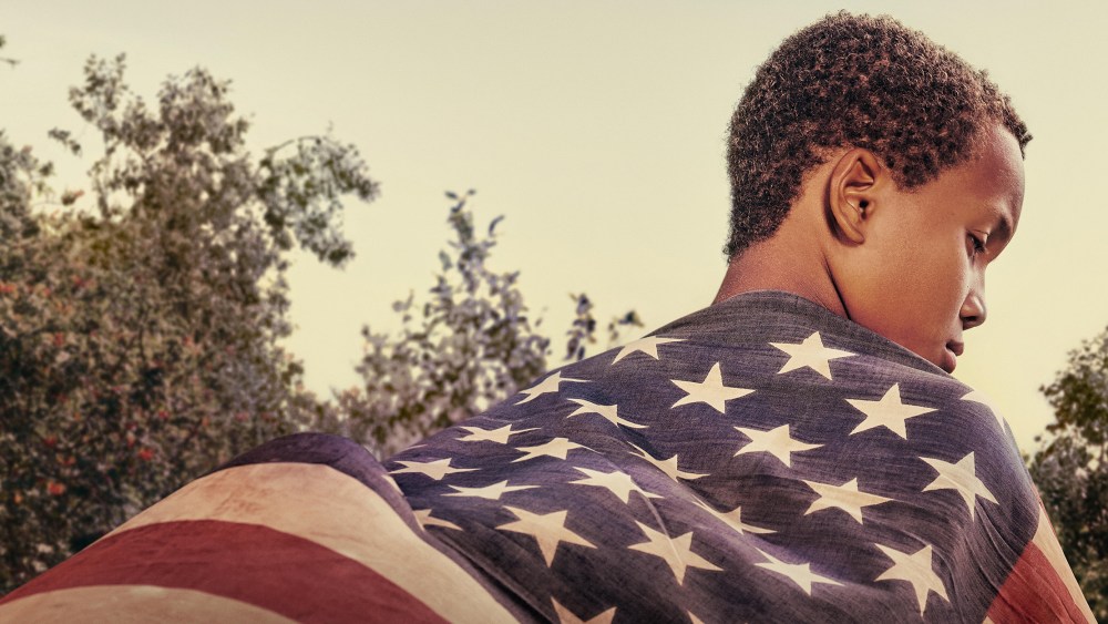 Image: Back of an Black boy wearing an American flag.
