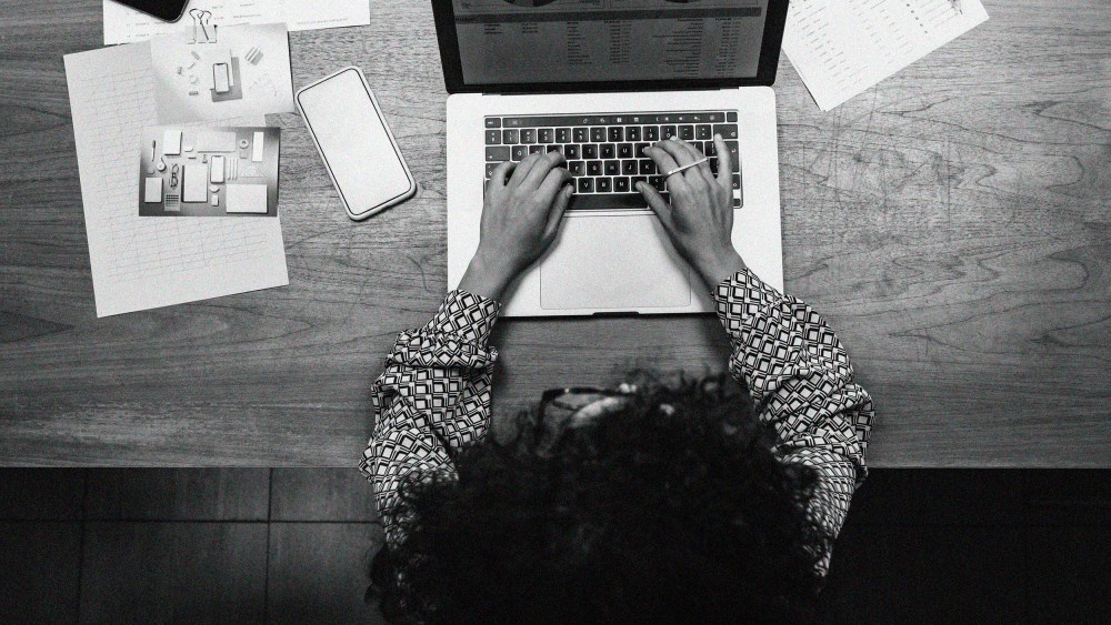 Overhead view of a Black woman working on a laptop