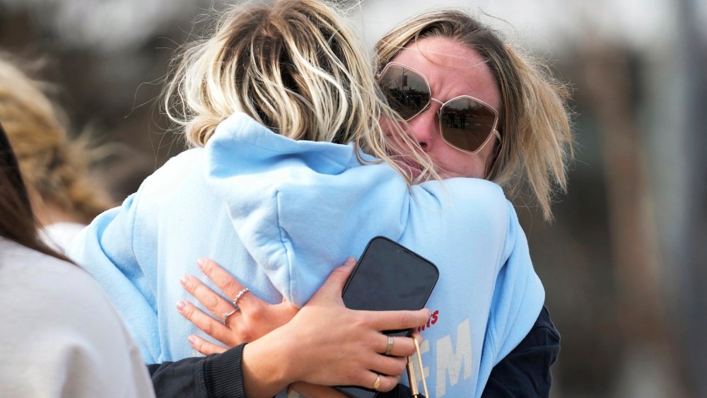 Students hug on the Michigan State University campus in East Lansing, Mich.