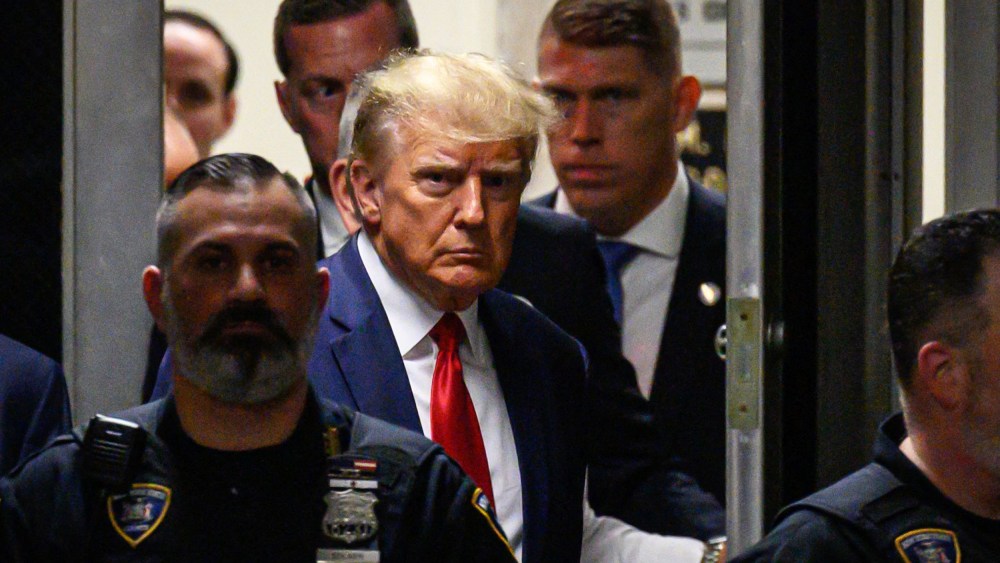 Former US President Donald Trump walks with security personnel as he makes his way inside the Manhattan Criminal Courthouse