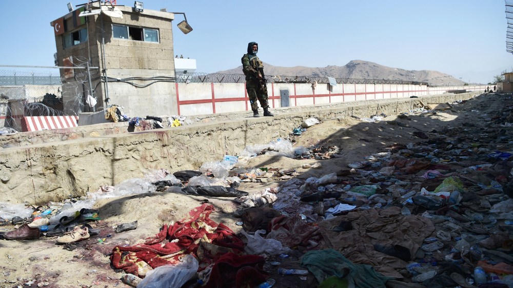 TOPSHOT - A Taliban fighter stands guard at the site of the August 26 twin suicide bombs, which killed scores of people including 13 US troops, at Kabul airport on August 27, 2021.