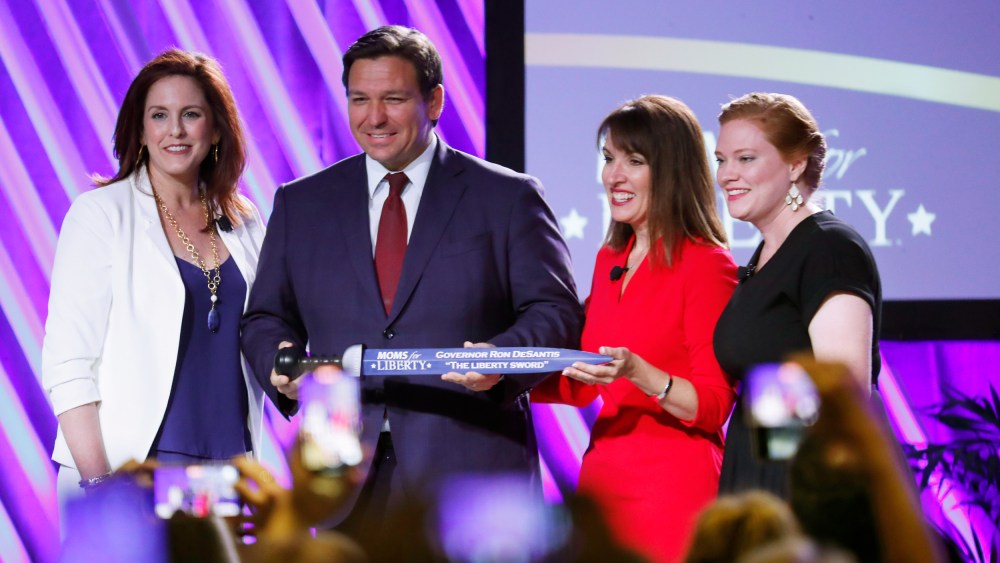 Tiffany Justice, Tina Descovich and Ron DeSantis on stage.