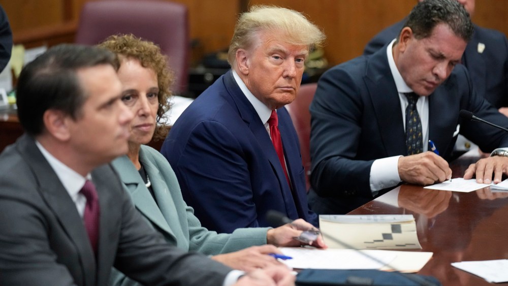 Former President Donald Trump sits at the defense table with his legal team in court