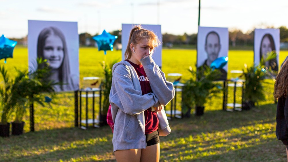 A woman visits a memorial for the victims of the Marjory Stoneman Douglas High School mass shooting in Parkland, Fla.