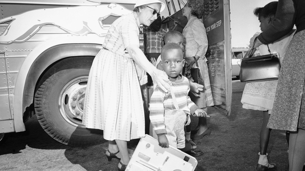 Two unidentified women, residents of Hyannis, Mass., help some of the nine children of Lela Mae Williams off the bus, June 8, 1962.