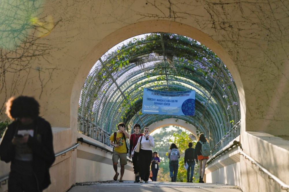 Students cross a bridge linking different sections of the campus, at New College of Florida on Feb. 28, 2023, in Sarasota.