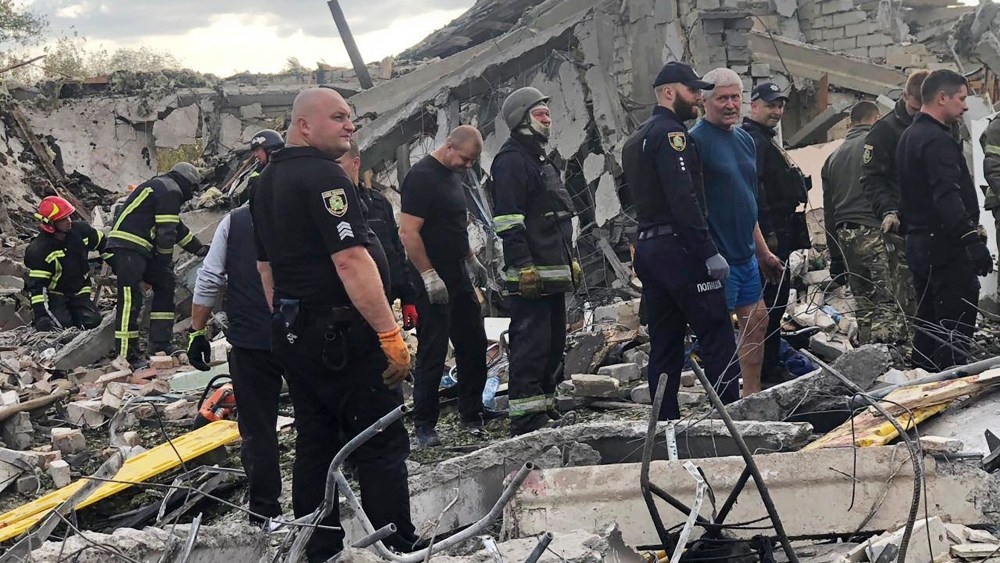 Emergency workers search for victims of the deadly Russian rocket attack that killed more than 40 people in the village of Hroza near Kharkiv, Ukraine.