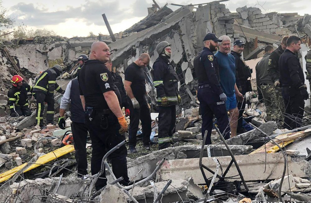 Emergency workers search for victims of the deadly Russian rocket attack that killed more than 40 people in the village of Hroza near Kharkiv, Ukraine.